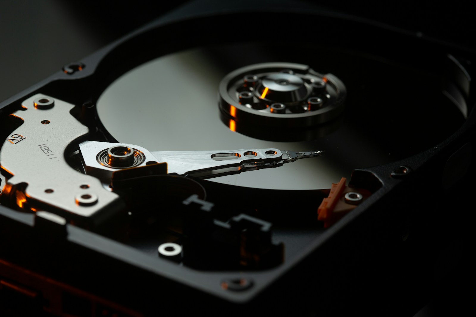 Inside a hard drive showing read/write head and platter — used for laptop data recovery in Perth