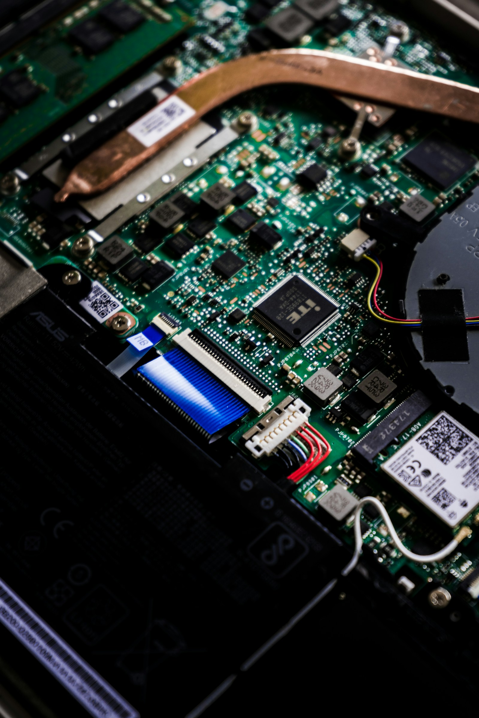 Laptop motherboard with heat pipe and components exposed during a Perth workshop repair